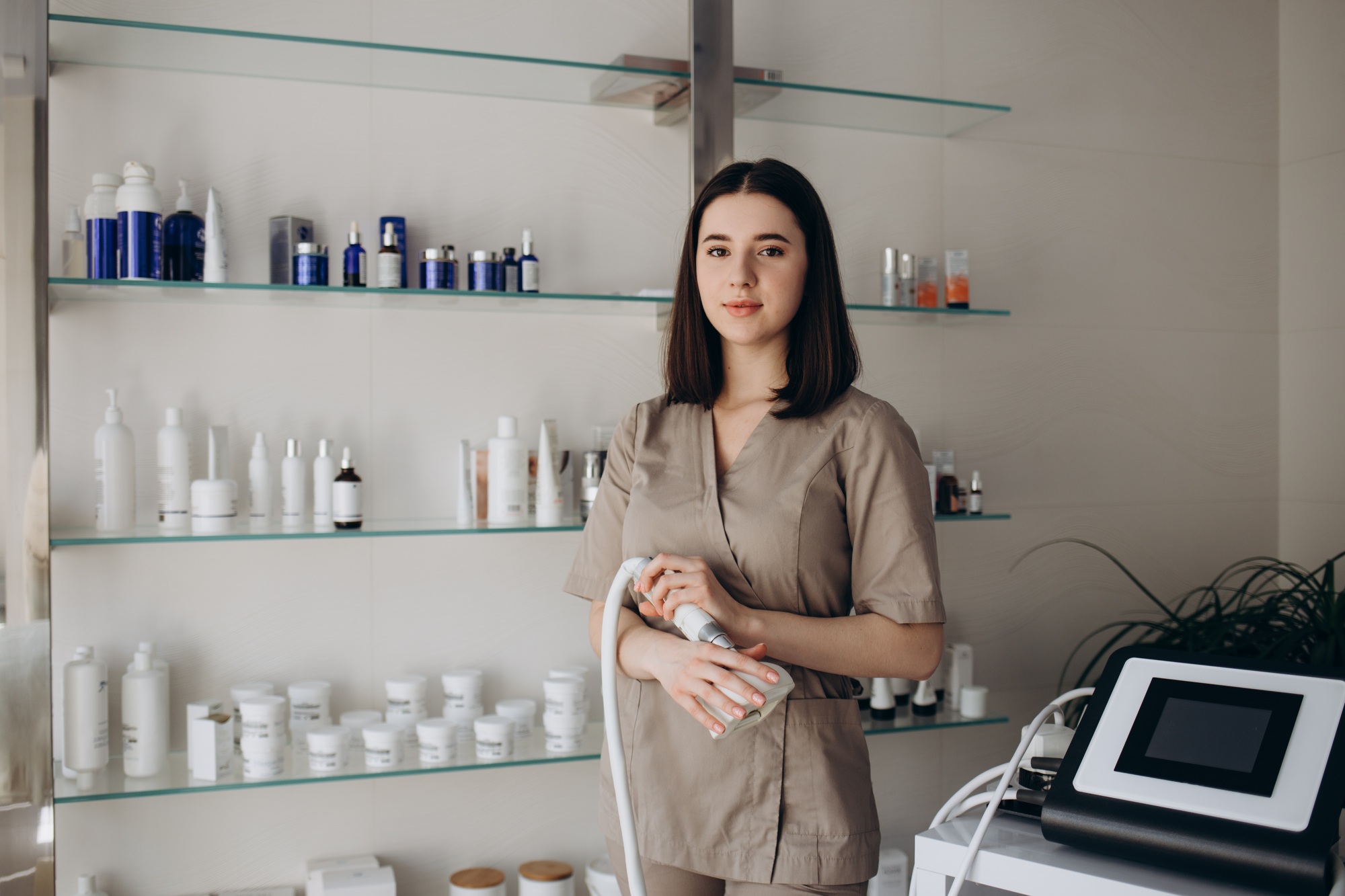 Beautician massaging woman's thigh with wooden vacuum cup at aesthetic clinic
